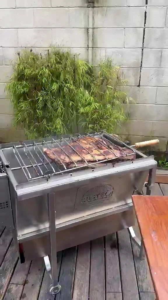 Churrasqueira Luxo em um deck de madeira de uma casa, com a costela assando