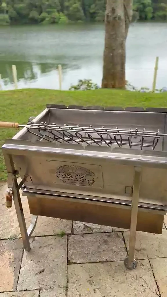 Churrasqueira Luxo em inox escovado em um terraço com gramado e lago ao fundo