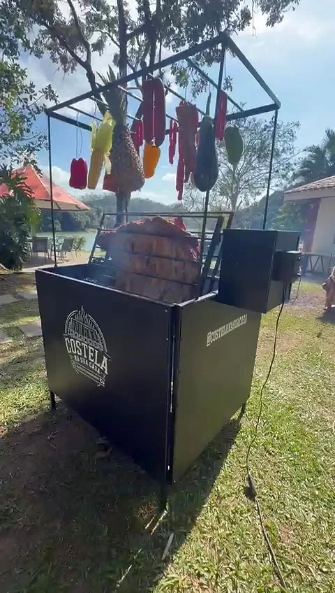 Churrasqueira Rústica em uma festa ao ar livre, com o varal cheio e a costela assando